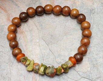 Puede incluir: Un brazalete de cuentas de madera marrón con una fila de cuentas de piedras preciosas verdes, rojas y naranjas.