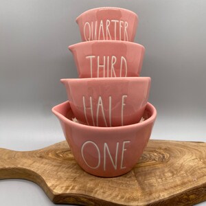 Set of pink/coral ceramic measuring cups with numbers spelled out and a heart on the inside. Rae Dunn Magenta ceramics. New and never used.