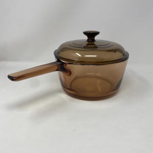 May include: A set of three ceramic mugs with a speckled, matte finish. The mugs are in shades of cream, light gray, and dark gray. Each mug has a simple, minimalist design, perfect for coffee or tea.