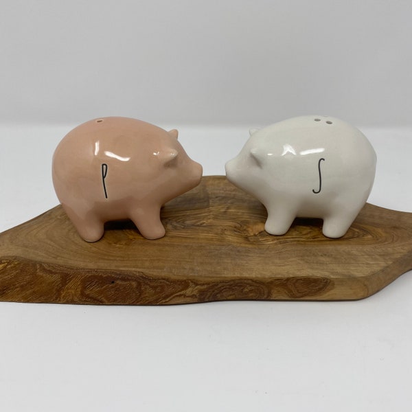 Rae Dunn ceramic pig salt and pepper shakers. New and never used. White and beige piggies. Each marked. 3” long and 2-1/2” tall. Come in box