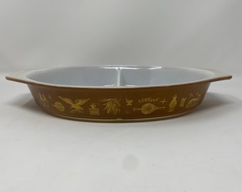 Pyrex Early American, 22k gold on brown background, divided 1-1/2 qt oval dish. Good vintage condition. No chips/cracks. Normal wear & tear