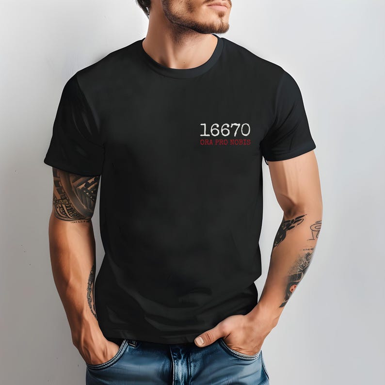 May include: A black t-shirt with white text that reads "16670 ORA PRO NOBIS".