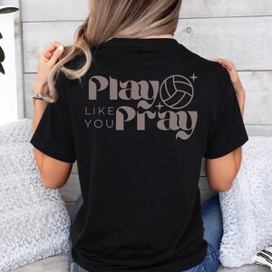 May include: Black t-shirt with a brown graphic that says "Play Like You Pray" with a volleyball graphic.