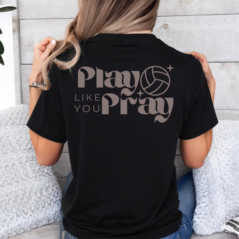 May include: Black t-shirt with a brown graphic that says "Play Like You Pray" with a volleyball graphic.