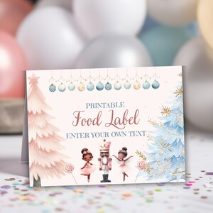Könnte beinhalten: Ein druckbares Lebensmitteletikett mit einem Aquarelldesign. Das Etikett zeigt einen rosa Weihnachtsbaum, einen blauen Weihnachtsbaum und einen Nussknacker mit zwei Ballerinas. Der Text lautet "Printable Food Label" und "Enter Your Own Text".