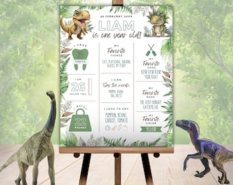Puede incluir: Un póster imprimible verde y blanco con temática de dinosaurios. El póster presenta una ilustración de dinosaurio y el texto "¡Liam tiene un año!" junto con detalles sobre la edad, la altura, el peso, las cosas favoritas y el color favorito del niño.