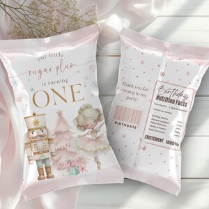 May include: Two custom chip bags featuring a nutcracker and a ballerina with pink Christmas trees. The front reads our little sugar plum is turning ONE. The back displays Birthday Nutrition Facts with text including Thank you for coming to my party.
