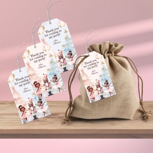 Könnte beinhalten: Drei weiße Geschenkanhänger mit einem Nussknacker- und Ballerina-Motiv. Die Anhänger zeigen eine schwarze und braune Ballerina in einem rosa Tutu und einen Nussknacker in einer rot-goldenen Uniform. Die Anhänger haben den Text "Vielen Dank, dass du zu meiner Party gekommen bist!" mit dem Namen "Bre. Maddie" unten.