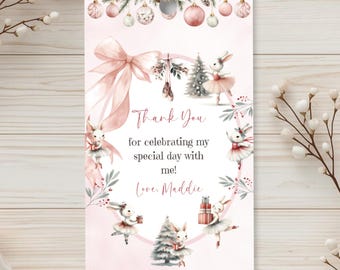 May include: A rectangular gift tag with a pale pink background featuring watercolor illustrations of ballet-dancing rabbits, Christmas trees, ornaments, and a large pink bow. The text reads: Thank You for celebrating my special day with me! Love, Maddie.