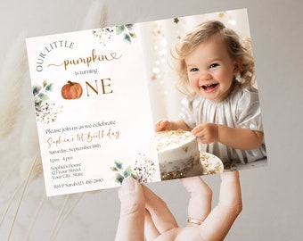 May include: A fall-themed first birthday invitation with a photo of a baby girl. The invitation features a pumpkin with the text "Our Little Pumpkin is turning One". The invitation also includes the text "Please join us as we celebrate Sophia's 1st Birthday, Saturday, September 18th, 1pm-4pm, Sophia's House, 123 Your Street, Your City, State, RSVP Sarah 123-456-7890."