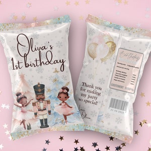 May include: A white chip bag with a Nutcracker theme for a 1st birthday party. The bag features a Nutcracker, two ballerinas, and snowflakes. The text on the bag reads "Olivia's 1st birthday". The back of the bag has a nutrition facts label with the text "Birthday Nutrition Facts" and "Excitement 1000%".