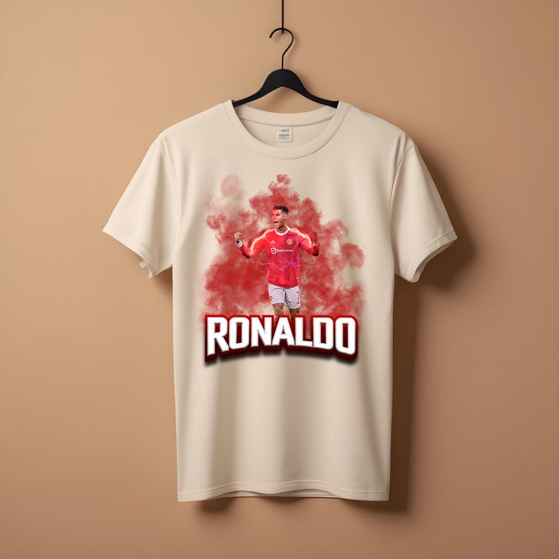 May include: A white t-shirt with a red and white image of a soccer player in a red jersey with the word "RONALDO" printed in red and white letters.
