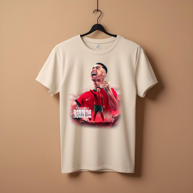 May include: White t-shirt with a graphic print of Cristiano Ronaldo in a red and green soccer uniform. The text "Cristiano Ronaldo" is printed below the image.