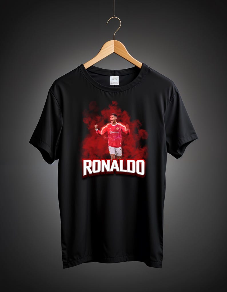 May include: Black t-shirt with a red and white image of a soccer player in a red jersey with the name "RONALDO" printed in white letters.