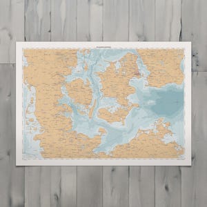 Pode incluir: Uma carta náutica retangular dos estreitos dinamarqueses com massas de terra em tom bege e profundidades de água em azul claro. O mapa exibe costas intrincadas, inúmeras ilhas e vários rótulos de navegação marítima em texto preto.