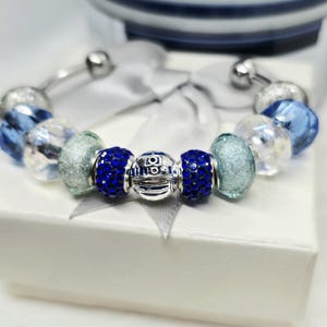 May include: A set of three ceramic mugs with a speckled, matte finish. The mugs are in shades of cream, light gray, and dark gray. Each mug has a simple, minimalist design, perfect for coffee or tea.