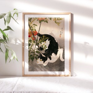 May include: A black and white cat with yellow eyes is curled up in a bush of red tomatoes. The cat is looking at the viewer. The image is a vintage Japanese woodblock print.