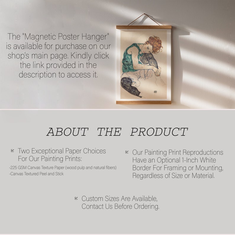 May include: A framed print of a woman in a green dress and black pants sitting with a black cat. The print is hanging on a white wall with natural light shining through the window. The text "ABOUT THE PRODUCT" is below the print.