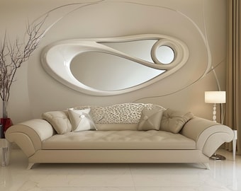 Puede incluir: Un sofá beige con asiento capitoné y cuatro cojines cuadrados, situado bajo un gran espejo de pared asimétrico con marco blanco, que presenta un diseño curvo y fluido con dos aberturas reflectantes distintas en una pared beige.