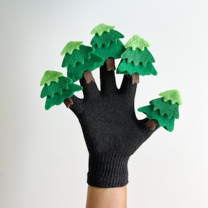 May include: Black finger puppet glove with five green felt finger puppets shaped like pine trees.