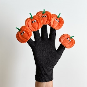 May include: Black finger puppet glove with five orange felt pumpkins with googly eyes attached to each finger.