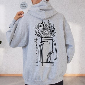 a woman wearing a gray hoodie with a flower vase on it
