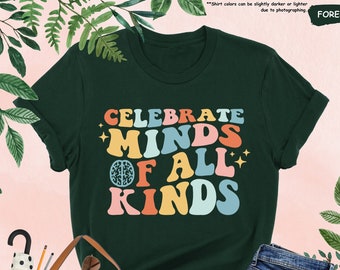 May include: A dark green t-shirt with a retro-style graphic that says "Celebrate Minds of All Kinds" in rainbow colors. The graphic includes a stylized brain.