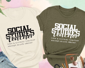 May include: Two t-shirts with the text "SOCIAL STUDIES Teacher like a normal teacher except much cooler." The shirts are in natural and heather olive colors.