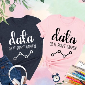 May include: Two t-shirts, one navy blue and one pink, with the text "data or it didn't happen" and a line graph graphic.