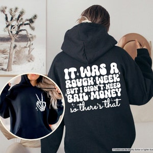 May include: Black hoodie with a white graphic print that reads "It was a rough week but I didn't need bail money so there's that".
