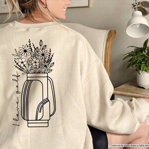 a woman sitting in a chair with a flower pot on her back