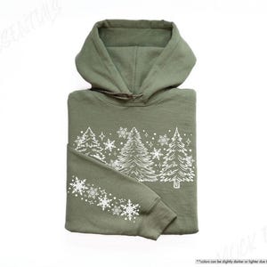 May include: A green hooded sweatshirt with a white design of stylized pine trees and snowflakes.