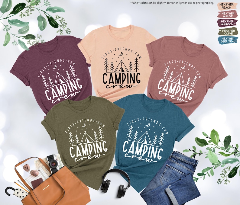 Peut inclure: Cinq t-shirts de diff&eacute;rentes couleurs avec un motif graphique blanc d'un feu de camp et d'arbres avec le texte "Fires Friends Fun Camping Crew".