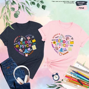 May include: Two t-shirts, one heather navy and one pink, featuring a graphic design representing the work of a school psychologist. The design includes icons such as reports, feelings, meetings, data, deadlines, and parent requests. The text on the shirts reads "School Psych".