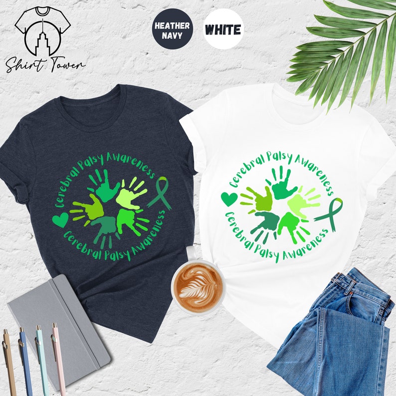 May include: Two t-shirts, one heather navy and one white, with a green handprint design that says "Cerebral Palsy Awareness".
