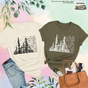 K&ouml;nnte beinhalten: Zwei T-Shirts mit einer Waldszene und dem Text 'of all the paths you take in life, make sure a few of them are dirt'. Das Shirt auf der linken Seite ist hellbeige und das Shirt auf der rechten Seite ist dunkelgr&uuml;n.