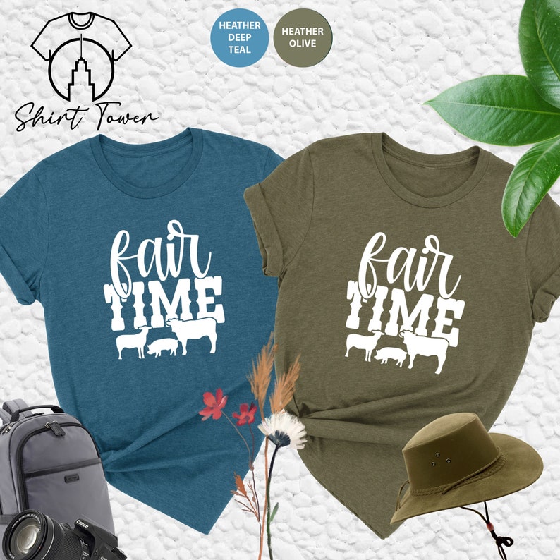 May include: Two t-shirts with the text "fair time" and a graphic of farm animals. The shirts are in heather deep teal and heather olive.