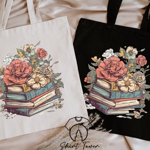 May include: Two tote bags featuring a floral design with a stack of books and flowers. The bag on the left is beige and the bag on the right is black.