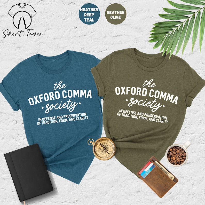 Op de afbeelding: Twee T-shirts met de tekst "the Oxford comma society." in witte letters op een teal en olijfgroene achtergrond. De tekst eronder luidt "In defense and preservation of tradition, form, and clarity."