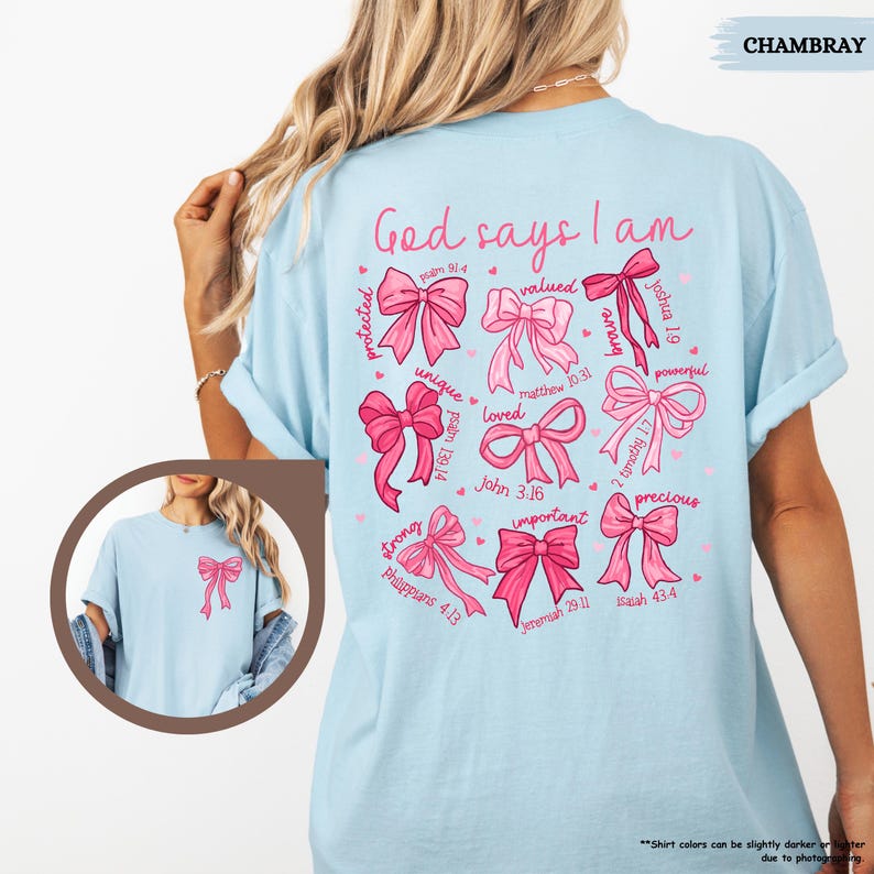K&ouml;nnte beinhalten: Hellblaues T-Shirt mit einem rosa-wei&szlig;en Design. Das Design zeigt einen Kreis aus Schleifen mit Bibelversen und den Worten "Gott sagt, ich bin".