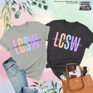 a couple of t - shirts that are next to a purse