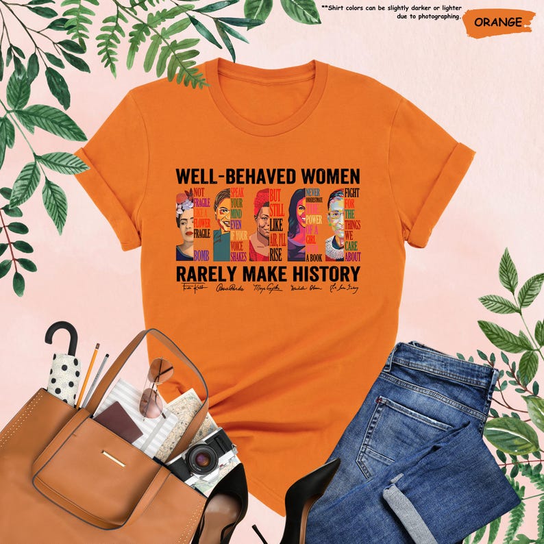 May include: Orange t-shirt with a graphic print of five women's faces and the text "WELL-BEHAVED WOMEN RARELY MAKE HISTORY". The text includes quotes from each woman.