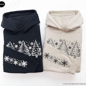 May include: Two hooded sweatshirts with a wintery design of trees and snowflakes. The sweatshirts are available in black and sand colors.