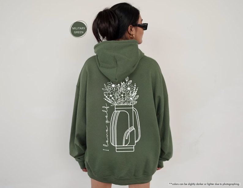 a woman wearing a green hoodie with flowers in a vase