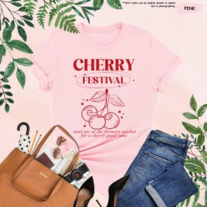 a pink shirt with cherry festival on it