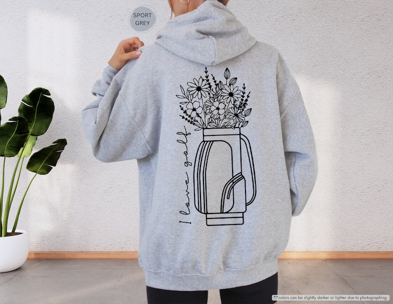 a woman wearing a gray hoodie with a flower vase on it
