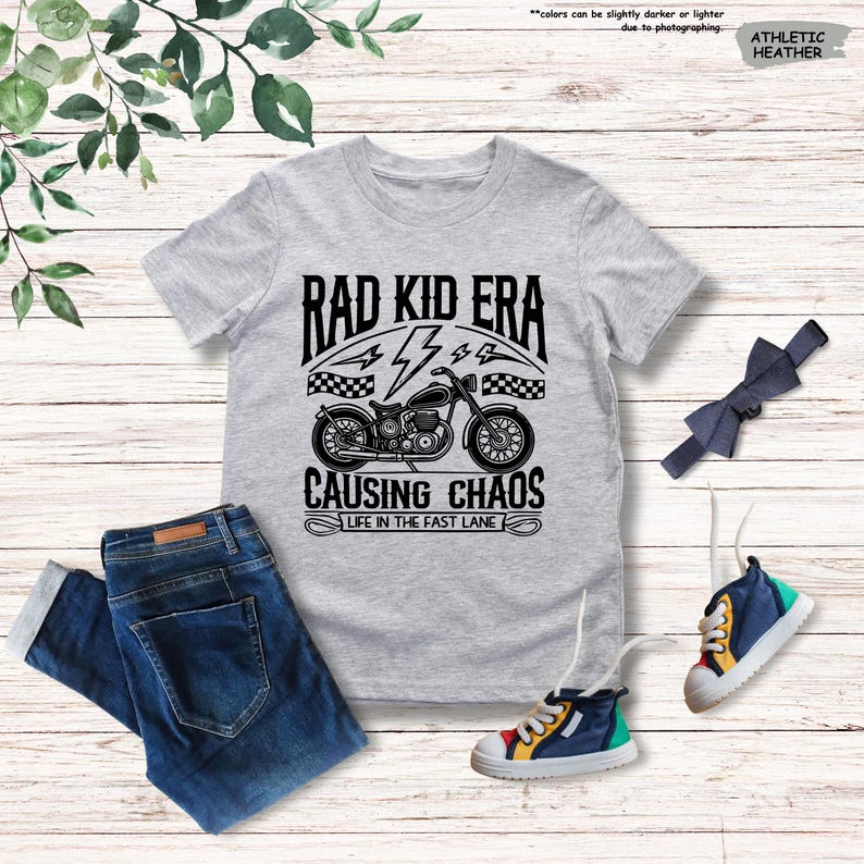 May include: Gray t-shirt with a black and white graphic of a motorcycle with the text "Rad Kid Era" and "Causing Chaos Life in the Fast Lane".