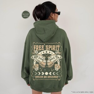a woman wearing a green hoodie with the words free spirit on it