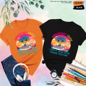 Puede incluir: Dos camisetas, una naranja y otra negra, con un dise&ntilde;o de crucero. El dise&ntilde;o incluye un crucero, palmeras y el texto "Anniversary Cruise 2026" y "I love it when we're cruisin together".