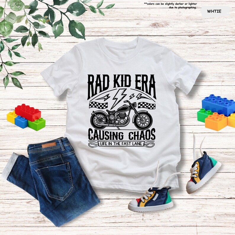 May include: White t-shirt with a black graphic of a motorcycle and the text "Rad Kid Era Causing Chaos Life in the Fast Lane".
